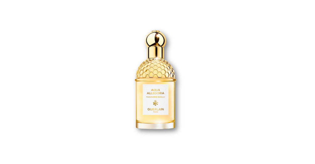 Guerlain Aqua Allegoria Mandarine Basilic bee bottle next to ripe mandarins and fresh basil sprigs in a sunlit garden, conveying a sweet, aromatic citrus scent.